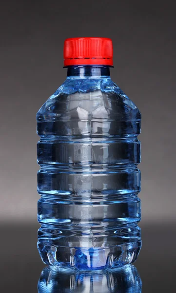 Plastic bottle of water on grey background — Stock Photo, Image