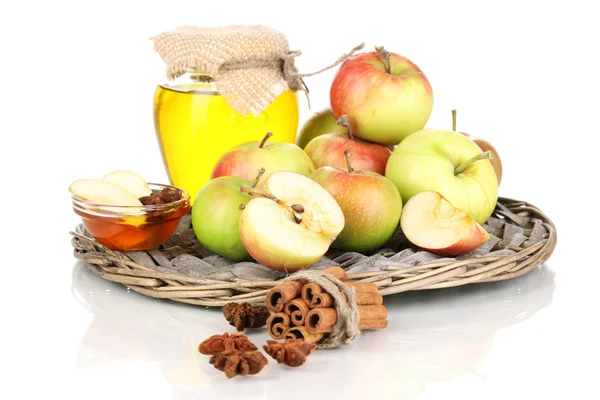 Honey and apples with cinnamon on wicker cradle isolated on white — Stock Photo, Image