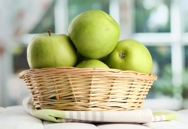 Reife grüne Äpfel mit Blättern im Korb, auf Holztisch, auf Fensterrücken — Stockfoto