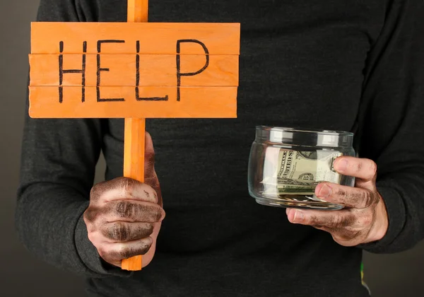 Homeless man asks for help, on black background close-up — Stock Photo, Image