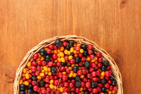 Barevné podzimní plody na proutěné podložky na detail dřevěné pozadí — Stock fotografie