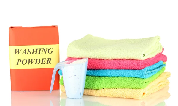 Box of washing powder with blue measuring cup and towels, isolated on white — Stock Photo, Image