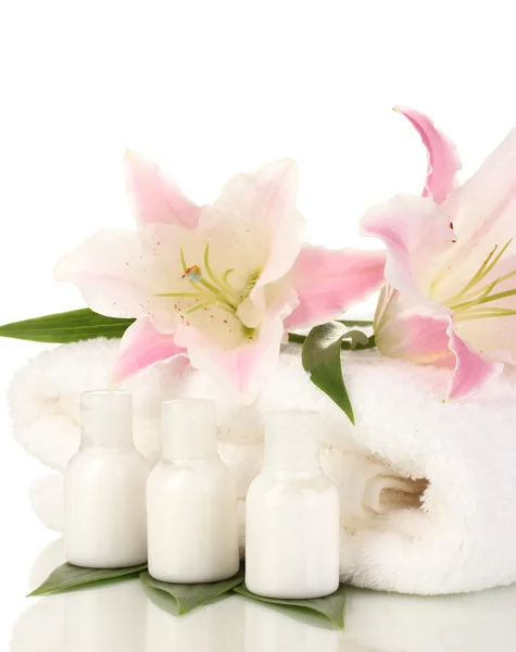 Schöne Lilie mit Handtuch und Flaschen isoliert auf weiß — Stockfoto