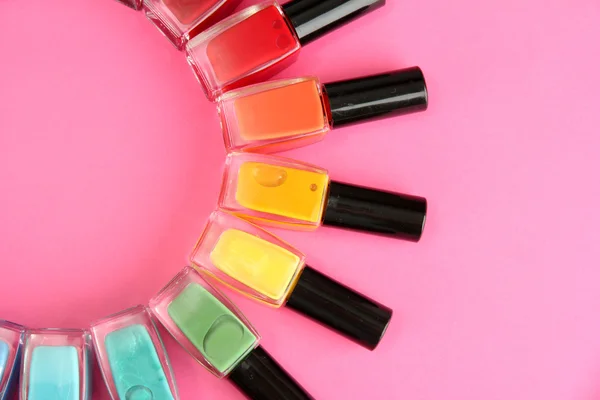 Group of bright nail polishes, on pink background — Stock Photo, Image