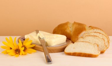 tahta sahibi ve bej renkli arka plan üzerinde tahta masada ekmek üzerine tereyağı