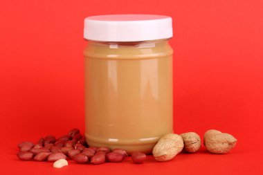 lezzetli fıstık ezmesi fıstık kırmızı zemin üzerine kavanoz içinde