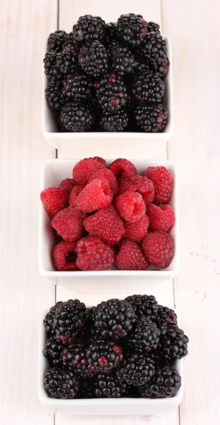 Ripe raspberries and brambles on wooden table — Stock Photo, Image