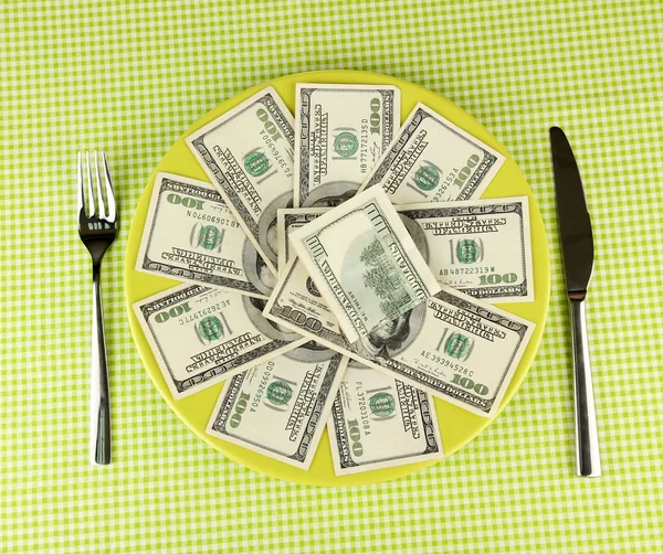 Банкноты на тарелке на зеленой скатерти крупным планом — стоковое фото