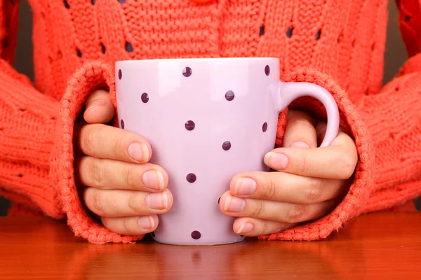 Руки держат кружку горячего напитка крупным планом — стоковое фото