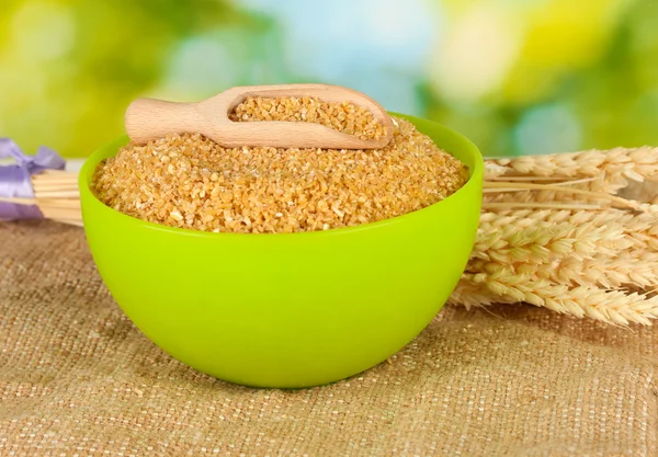 Arnautka in green bowl with spikelets on green background close-up — Stock Photo, Image
