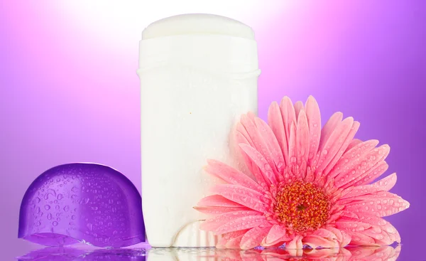 Dezodorant z kwiatów na fioletowym tle — Zdjęcie stockowe