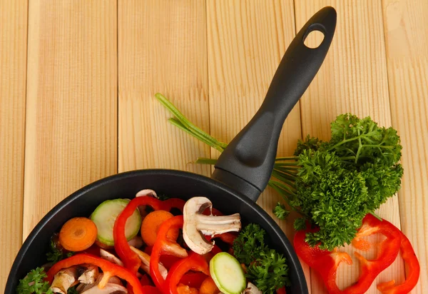 Koekenpan met groenten op houten achtergrond — Stockfoto