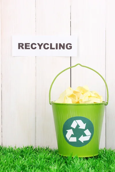 Reciclagem bin na grama verde perto de cerca de madeira — Fotografia de Stock