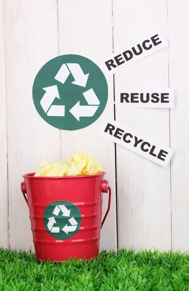 Reciclagem bin na grama verde perto de cerca de madeira — Fotografia de Stock