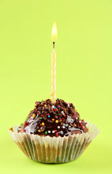 Tasty birthday cupcake with candle, on green background — Zdjęcie stockowe