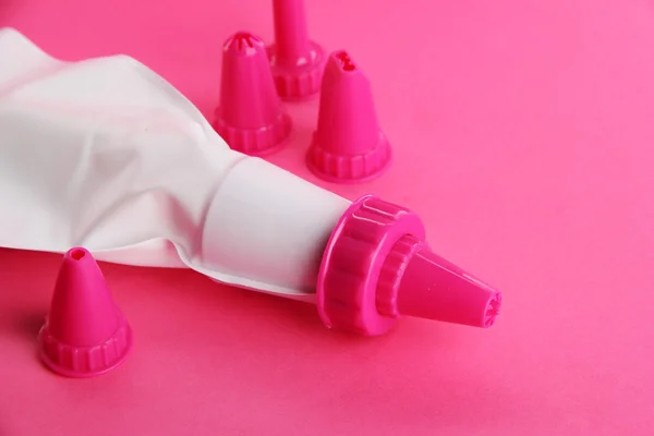 Confectionery bag and replaceable nozzles, on pink background — Stock Photo, Image