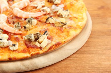 ahşap arka plan üzerinde durmak üstünde deniz ürünleri ile lezzetli pizza