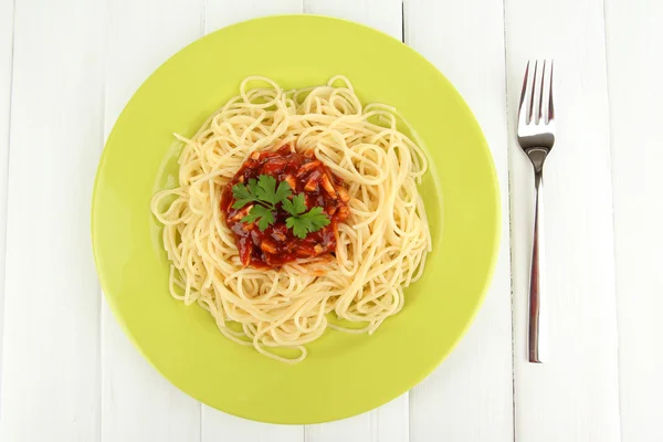 Italian spaghetti in plate on wooden table — Stock Photo, Image