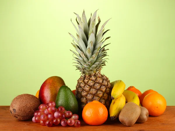 Stillleben von Früchten auf einem Tisch vor grünem Hintergrund — Stockfoto