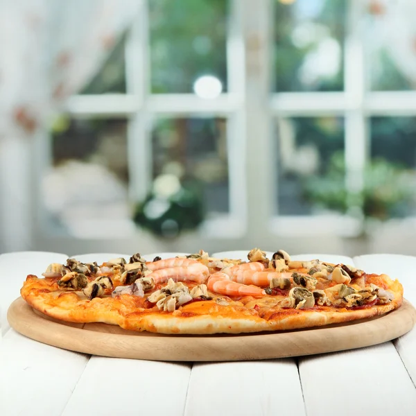 Deliziosa pizza con frutti di mare sul tavolo su sfondo luminoso — Foto Stock