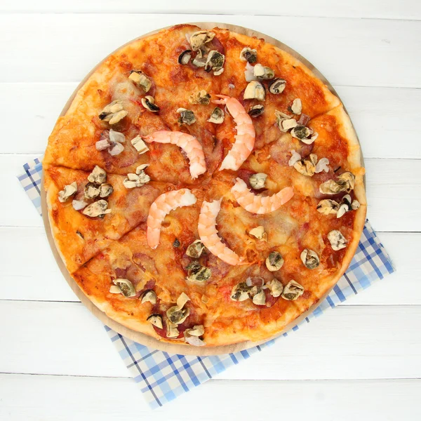 Heerlijke pizza met zeevruchten op stand op houten achtergrond — Stockfoto