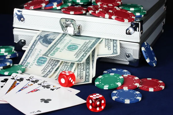 Mala com dólares na mesa de poker azul — Fotografia de Stock