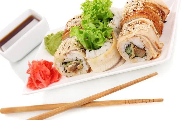 Deliciosos rollos servidos en plato blanco con palillos aislados en blanco — Foto de Stock