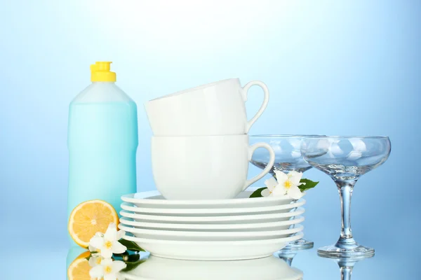 Platos limpios vacíos, vasos y tazas con líquido lavavajillas y limón en b —  Fotos de Stock