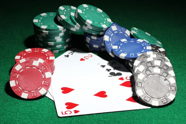 Karty a čipy pro poker na zeleném stole — Stock fotografie