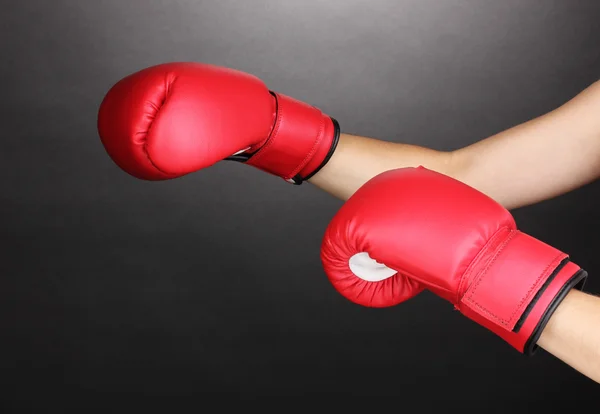 Luvas de boxe vermelho nas mãos sobre fundo cinza — Fotografia de Stock
