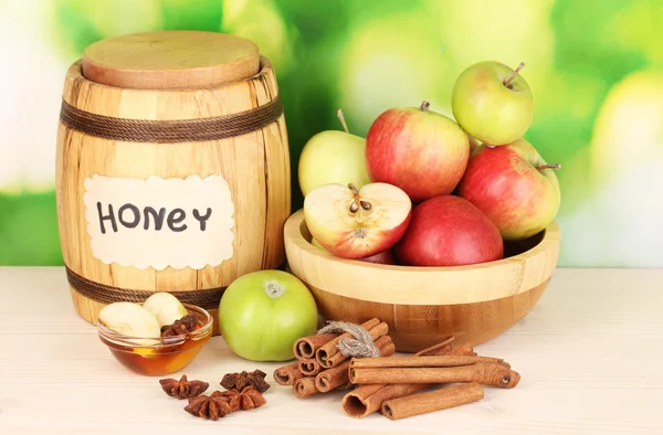 Honey and apples with cinnamon on wooden table on natural background — Stock Photo, Image