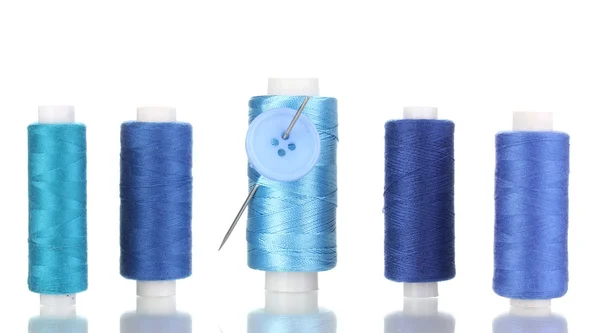 Many blue bobbin with needle and buttons isolated on white — Stock Photo, Image