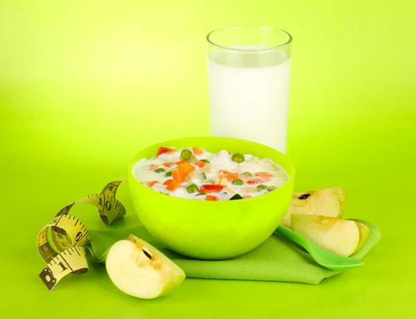Tasty dieting food and glass of milk, on green background — Stock Photo, Image