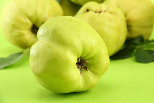 Sweet quinces with leaves, on green background — Stock Photo, Image