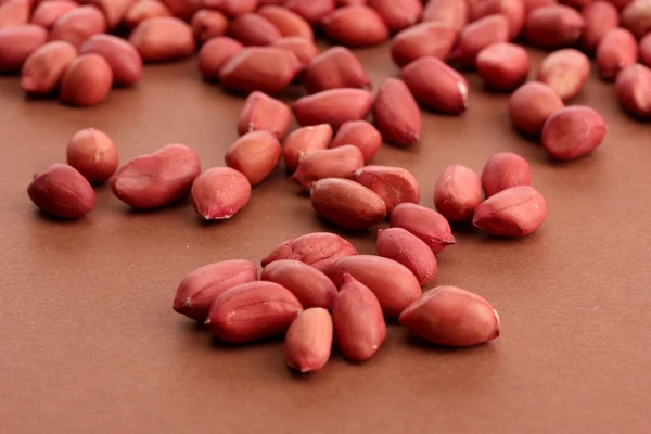 Amendoins saborosos, no fundo marrom — Fotografia de Stock