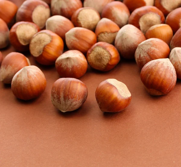 Chutné lískové ořechy, na hnědé pozadí — Stock fotografie