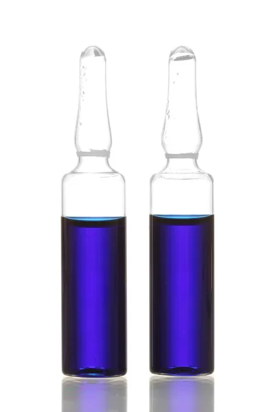 Na białym tle medyczne ampułki z błękitnym płynem, — Zdjęcie stockowe