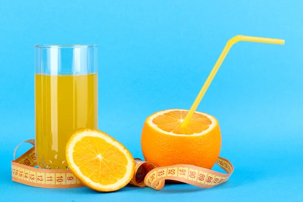 Rijp sinaasappelen en SAP als symbool van het dieet op blauwe achtergrond — Stockfoto