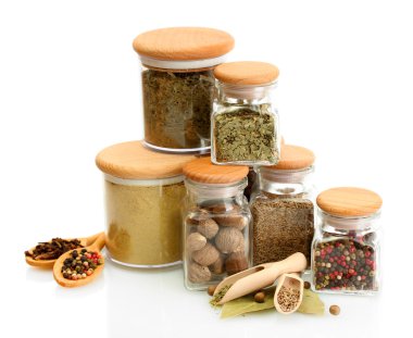 Kavanozlar ve tahta kaşıklar üzerinde beyaz izole baharatlar ile