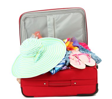 Suitcase with summer clothes, a hat and suntan isolated on white