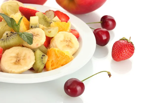 Vers fruit salade op plaat en bessen geïsoleerd op wit — Stockfoto