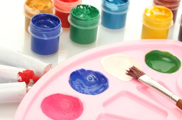 Tubes with colorful watercolors and jars with gouache and palette on white — Stock Photo, Image