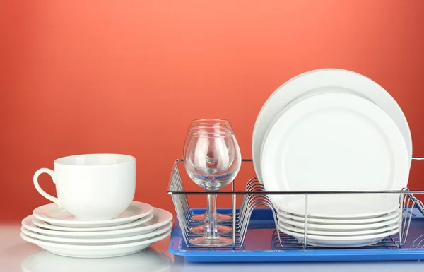 Platos limpios en pie sobre fondo rojo — Foto de Stock