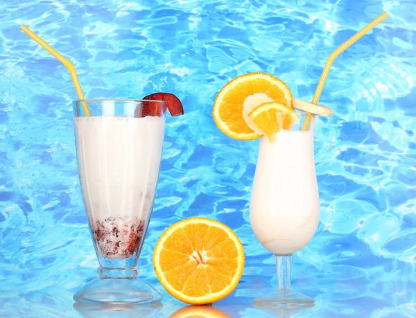 Heerlijke milkshake met fruit op tafel op blauwe zee achtergrond — Stockfoto