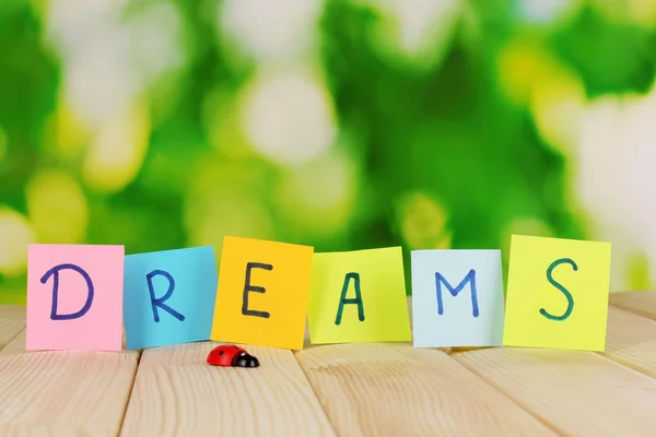 The word Dreams on wooden table on natural background — Stock Photo, Image