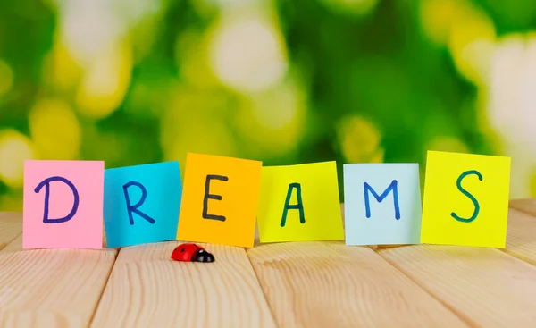 The word Dreams on wooden table on natural background — Stock Photo, Image