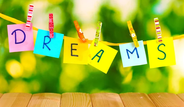 The word Dreams on wooden table on natural background — Stock Photo, Image