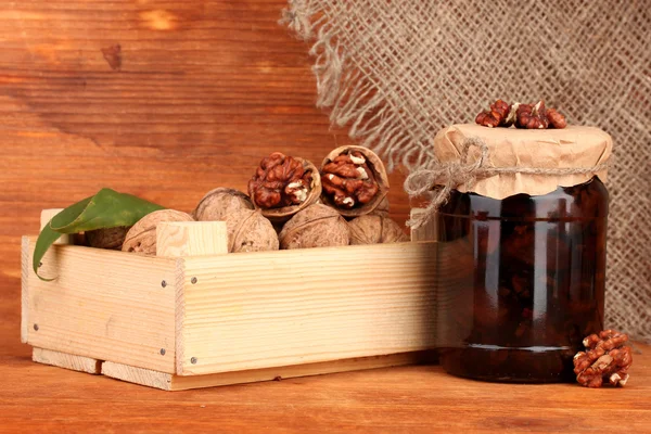 Mermelada de nueces y caja de madera sobre fondo de madera —  Fotos de Stock
