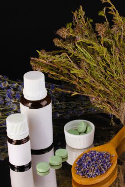 siyah arka plan üzerinde otlar ve ilaç şişeleri. homeopati kavramı