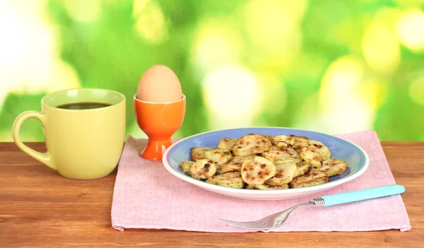 Zucchine fritte con uova e caffè a colazione sul tavolo di legno verde — Foto Stock